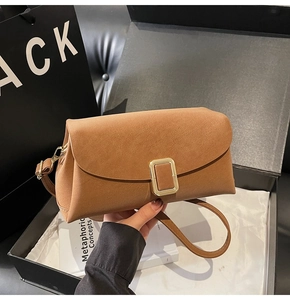 Détail d'un sac carré vintage marron avec boucle dorée et texture en similicuir