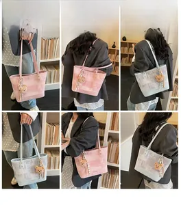 Lifestyle view of large tote bags in pink and blue with geometric patterns and bear charms