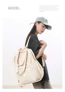 Side view of a creamy white lightweight nylon backpack with spacious compartments for travel