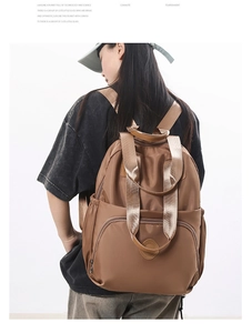 Detail of caramel brown waterproof nylon backpack with large main compartment and side pockets