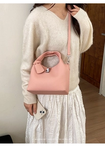 Pink lychee grain leather bucket bag with silver twist lock and minimalist retro vibe