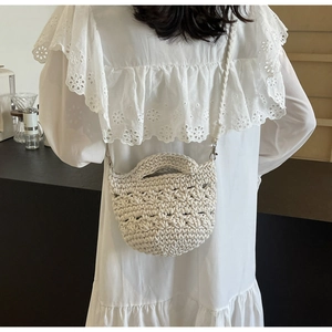 Detail of hand-woven cream crochet shoulder bag showing textured honeycomb knit pattern