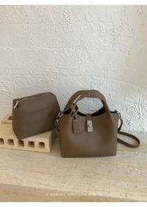 Detail of mocha lychee pattern bucket bag with silver metal lock and inner pouch