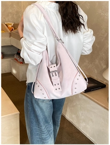 Close-up of pink tote bag featuring silver metal studs and buckle details on a side view