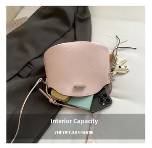 Detail view of pink crossbody bag interior with phone and notepad in daily use