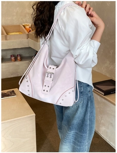 Close-up of pink tote bag with silver metal buckles, studs and decorative zippers details