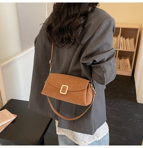 Détail du sac en daim caramel avec boucle dorée et options de double bandoulière