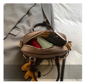 Detailansicht der braunen Ledertasche von oben mit Platz für Handy und Geldbörse