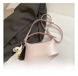 Detailed view of light pink cracked leather bag with adjustable strap and pony charm