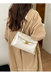 Détail du sac bandoulière minimaliste en cuir blanc cassé avec fermoir doré tournant