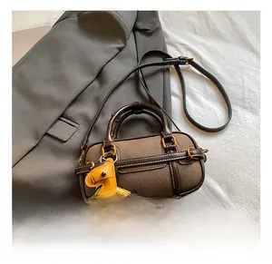 Detail der dunkelbraunen Leder-Handtasche mit weißen Kontrastnähten und Pferdeanhänger