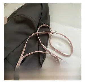 Detail of adjustable shoulder strap with silver buckle and cute cat pendant on pink bag