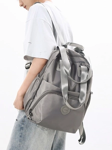 Grey large capacity multi-pocket travel backpack for women shown on model profile view