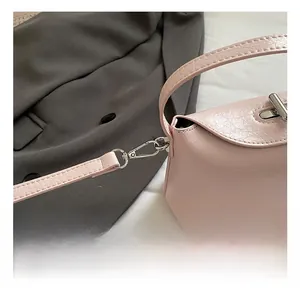 Detailed close-up of pink litchi grain leather bag with premium silver metal hook strap