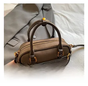 Makroaufnahme der braunen Lederhandtasche mit Kieselmaserung und goldenem Reißverschluss