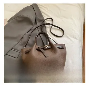 Détail d'un sac à main en cuir marron foncé à motif litchi sur fond de style de vie