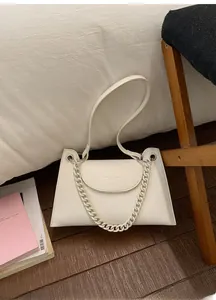 Detail view of beige lychee pattern bag with thick chain and silver hardware accents