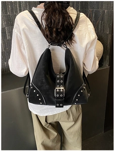Detailed close-up of a black punk-style tote bag with silver metal studs and eyelets