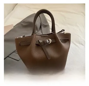 Détails du sac en cuir marron avec motif litchi, boucle métallique dorée et poignée élégante