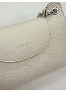 Macro detail of creamy white lychee grain leather bag with embossed classic logo