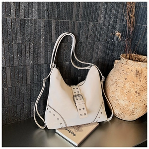 Detailed close-up of cream white rivet tote bag with vintage silver metal hardware accents