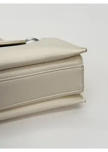 Detailed side view of white lychee leather bag showing triple compartment structure