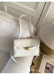 Gros plan détaillé du sac à bandoulière blanc crème rétro avec fermoir métallique doré