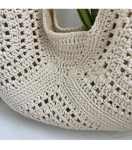 Close-up of beige crochet tote bag with hollow grid pattern and artisanal knit detail