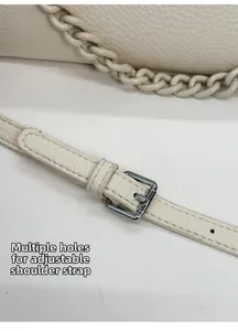 Close-up of cream lychee leather shoulder strap with adjustable silver buckle