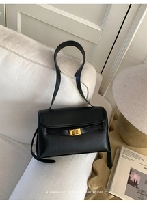 Détail d'un sac à bandoulière en cuir noir avec un fermoir rotatif doré sophistiqué