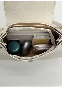 Interior view of the cream leather crossbody bag showing spacious storage for essentials