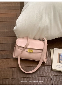 Gros plan détaillé d'un sac bandoulière rétro rose avec fermoir pivotant doré