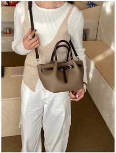 Détail du sac à main en cuir marron avec boucle argentée et bandoulière réglable