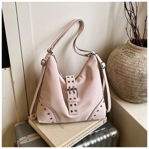 Detail of light pink nylon tote bag with metal buckle and rivets on vintage books