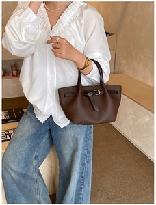 Détail d'un sac à main en cuir marron grainé avec boucles argentées et style élégant