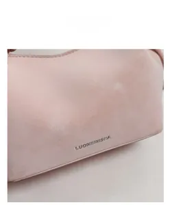 Makrodetail aus weichem rosa Leder mit Litschi-Muster und Silberlogo der Eimertasche