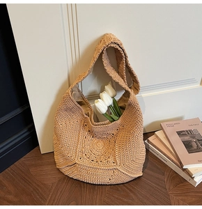 Détail d'un grand sac hobo en maille beige avec doublure sur un sol en bois élégant