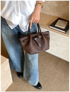 Détail d'un sac à main marron en cuir grainé avec boucle décorative de style vintage