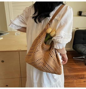 Detailed side view of khaki woven tote bag with brown leather strap on model