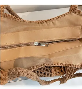 Détail d'un sac tissé avec fermeture éclair en métal argenté et doublure intérieure