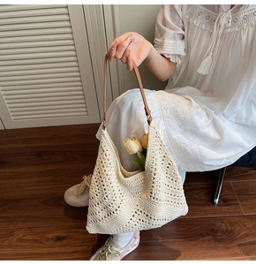 Close-up of cream woven tote bag with brown leather handles and hollow diamond pattern
