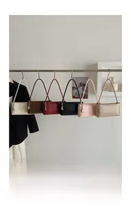 Detail view of colorful baguette shoulder bags with silver chain pendants hanging on a rack