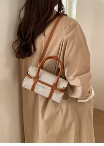 Modella che indossa una borsa a mano in tela con finiture in pelle e tracolla