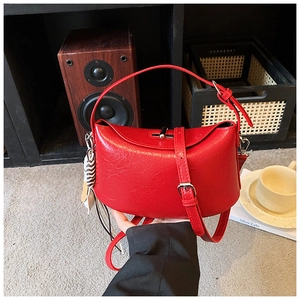 Close-up of red leather handbag showing lychee texture and silver metal bar twist lock