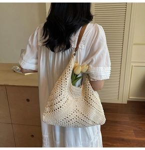 Detail of hand-woven cream hollow-out knit tote bag with bohemian diamond texture