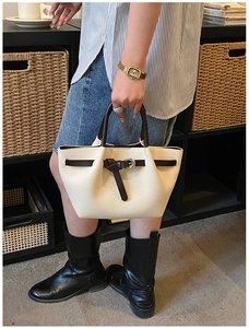 Détail du sac cabas en cuir crème avec anses marron et texture cuir grainé élégante