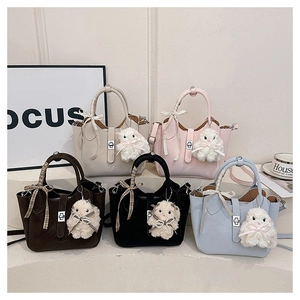 Détail de sacs seaux en cinq couleurs avec poignées rubans et breloques mouton