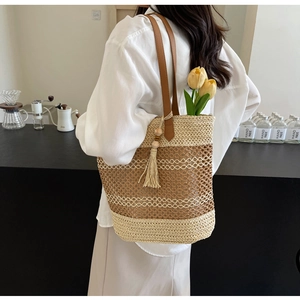 Detail of bohemian woven tote bag with fringe charm and caramel contrast stitching