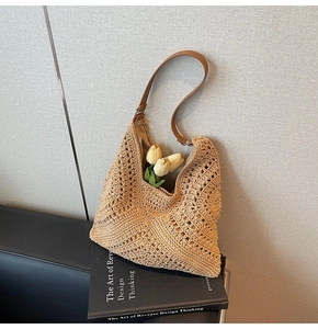 Detail of hollow woven shoulder tote bag with brown leather strap and tulip decoration