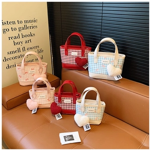 Mini bucket handbags set with checkered patterns and plush heart charms on a bench